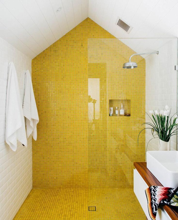 Piastrelle gialle nell'ampia doccia